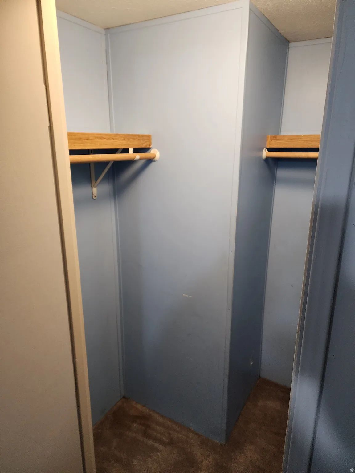 Walk in closet featuring dark carpet