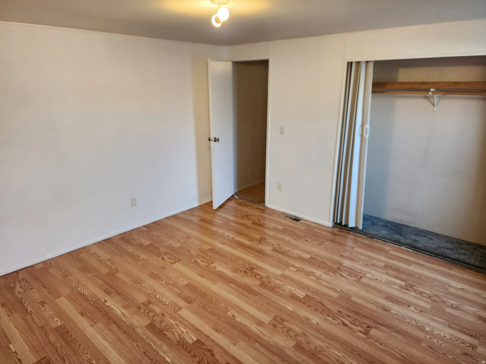 Unfurnished bedroom with light wood-type flooring and a closet