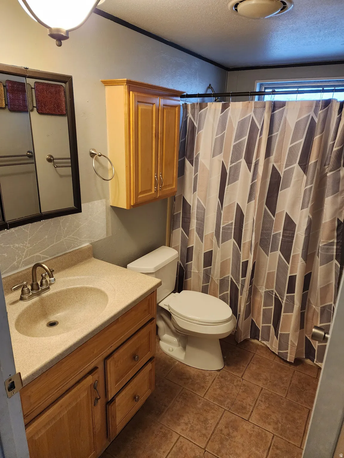 Full bath with vanity, a shower with shower curtain, and a textured ceiling