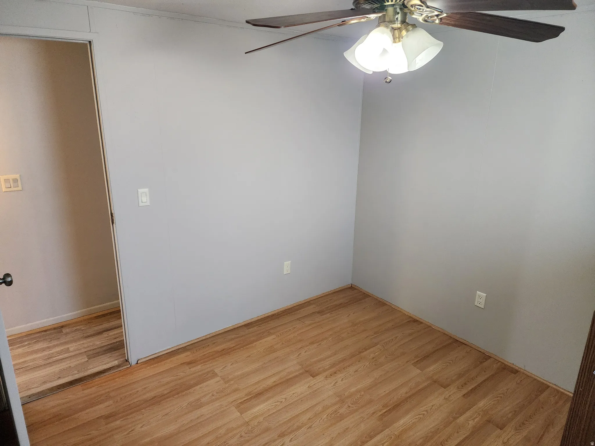 Unfurnished room with a ceiling fan and light wood-style flooring