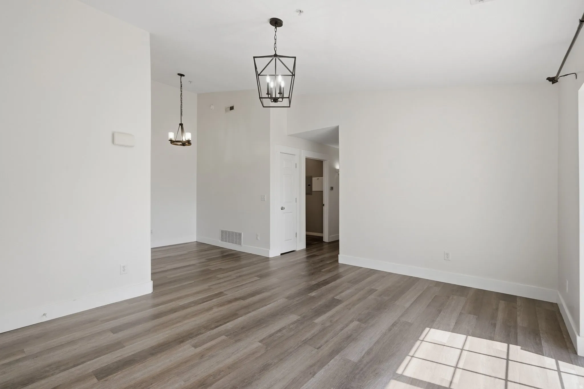 Unfurnished room with a chandelier and light wood-style flooring