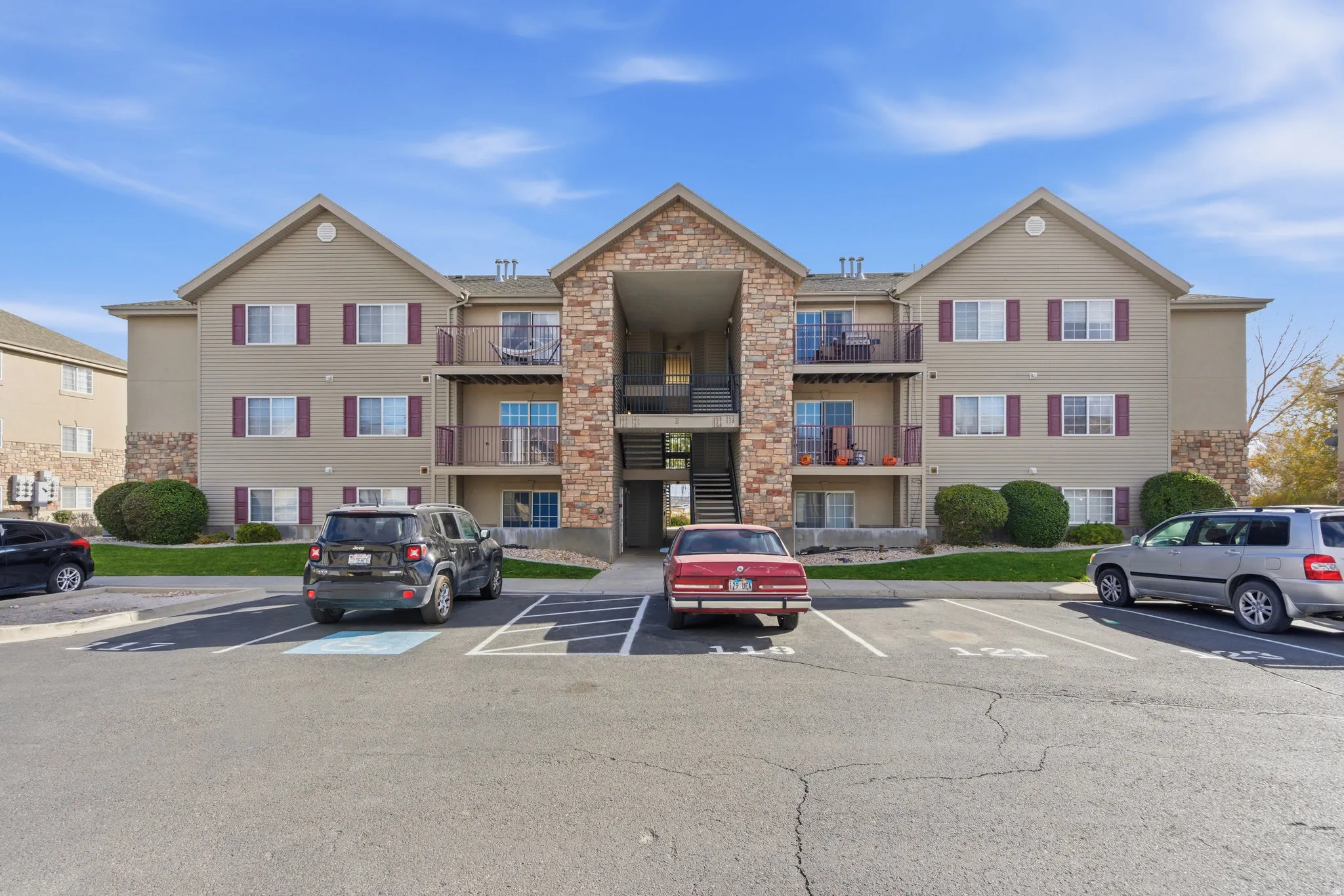 View of apartment building / complex featuring uncovered parking