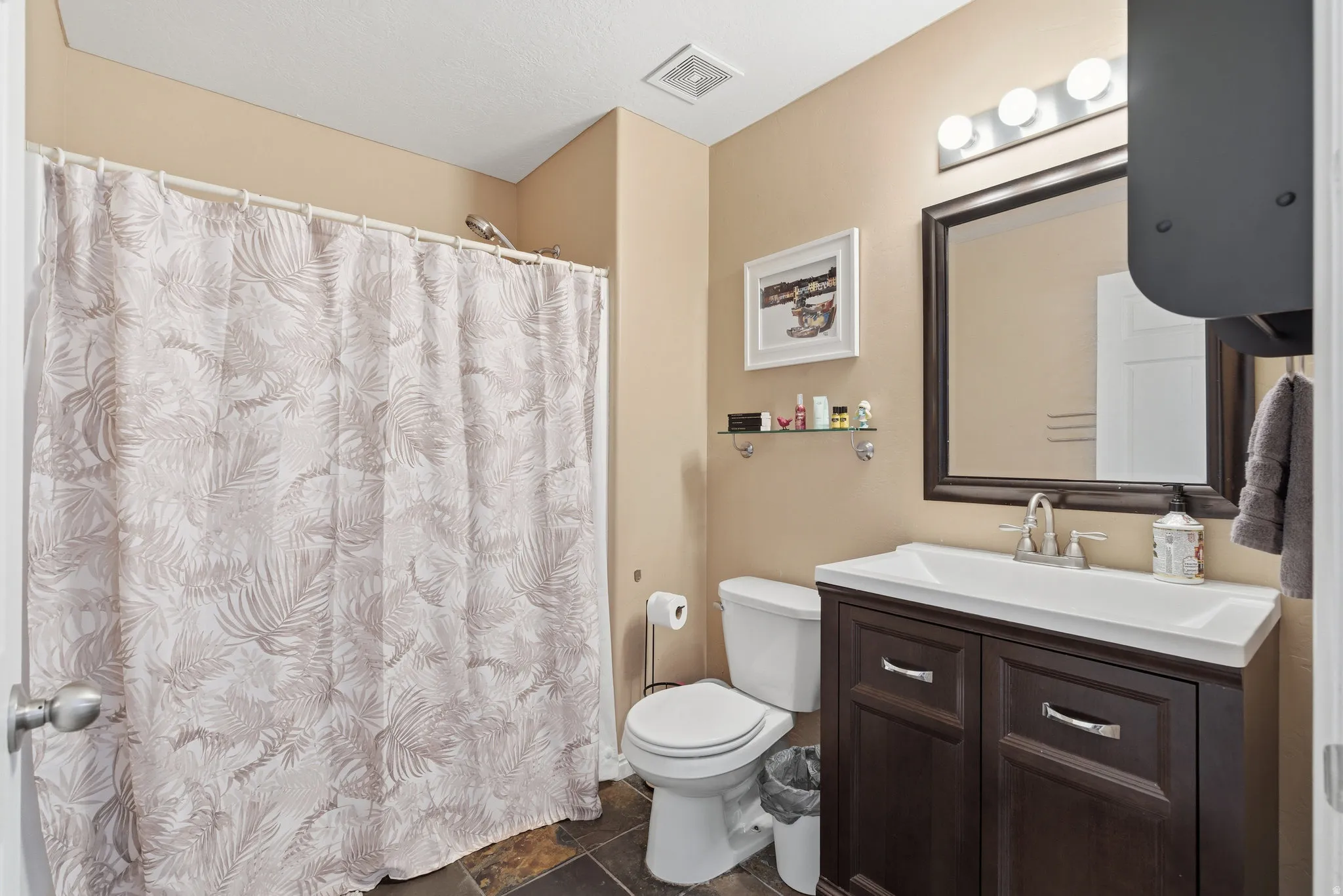 Bathroom featuring a shower with shower curtain and vanity