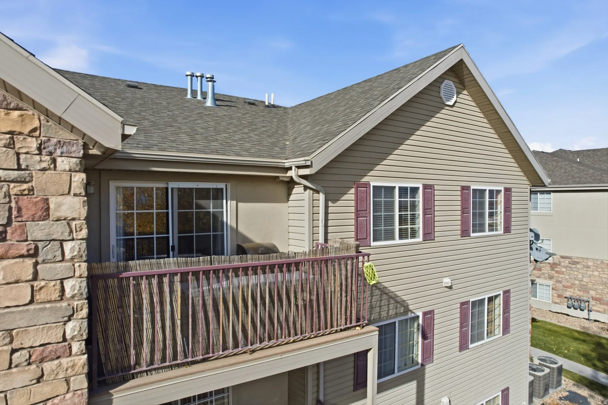 View of side of property with a shingled roof and a central AC unit