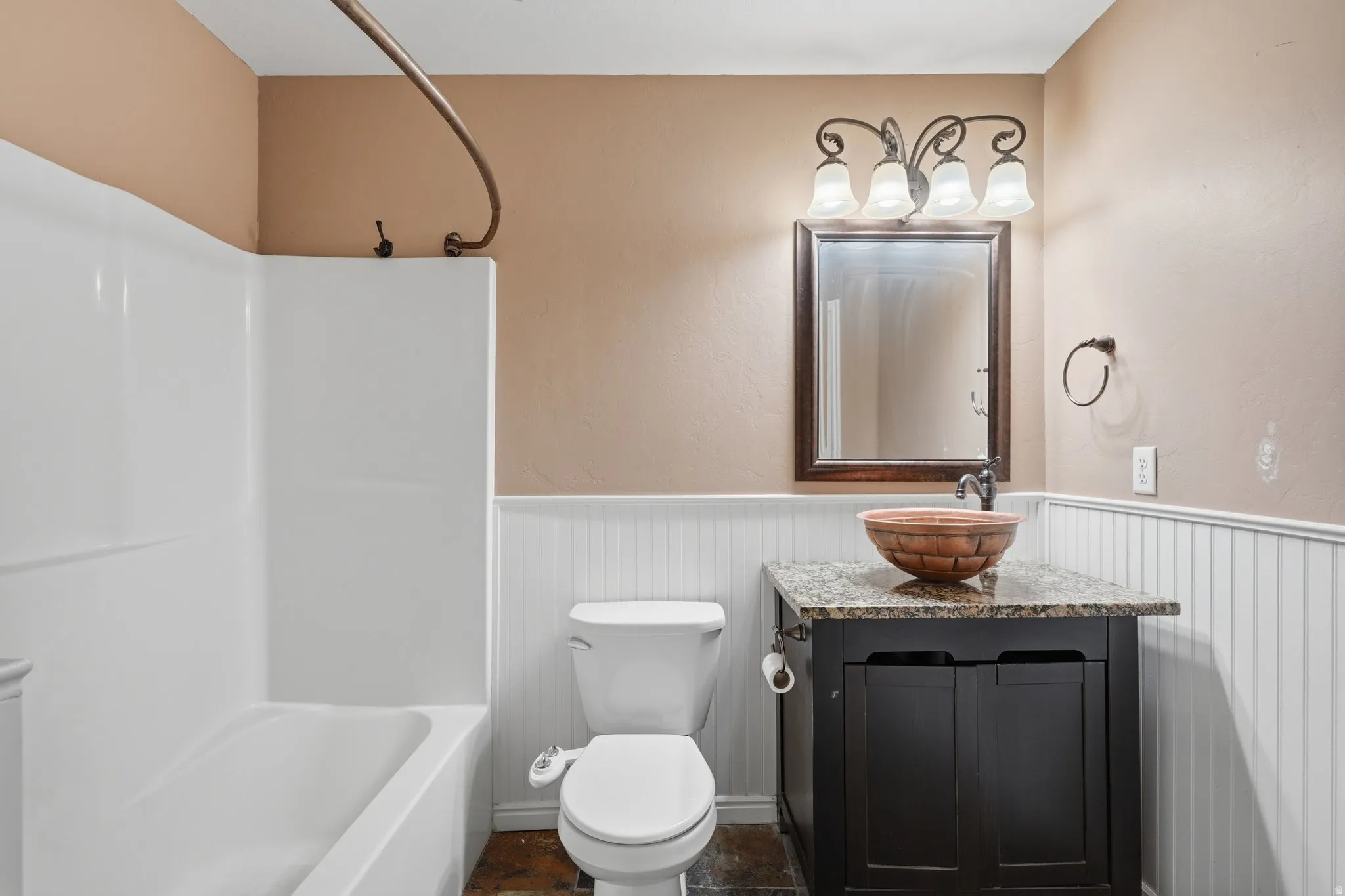 Bathroom with vanity, a wainscoted wall, and shower / washtub combination