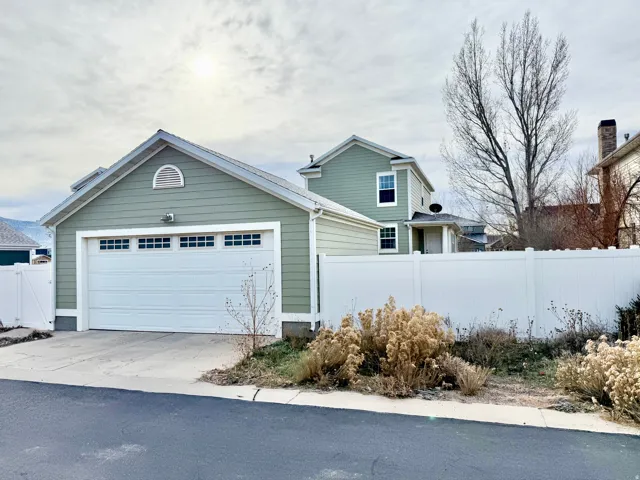 View of side of home featuring driveway and a detached garage