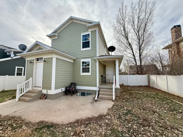 Back of house with a fenced backyard and a patio