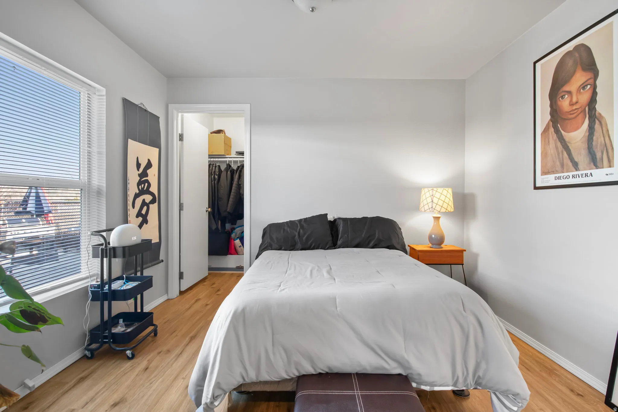 Bedroom featuring a spacious closet and light wood-style flooring