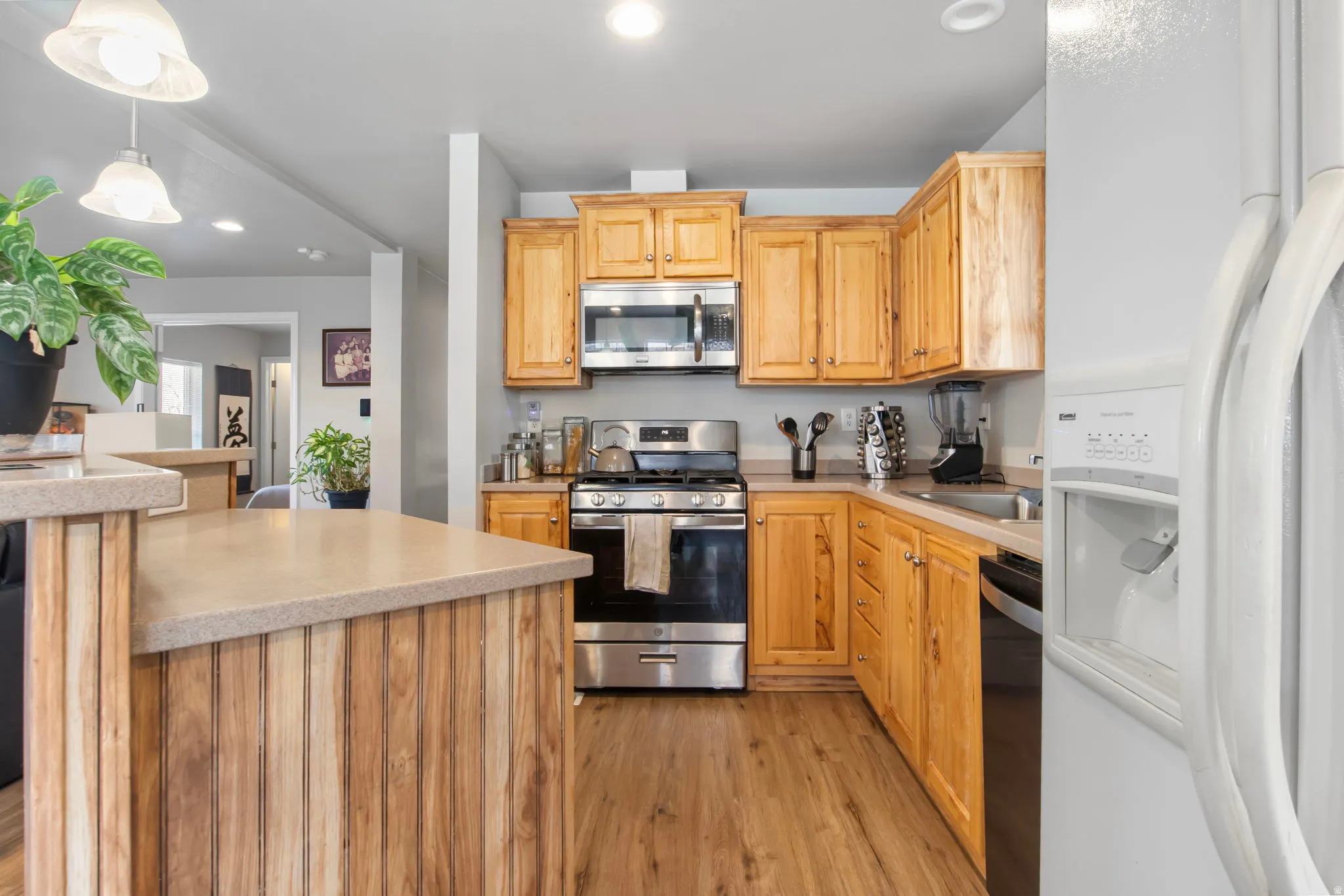Kitchen with stainless steel appliances, pendant lighting, light wood-style flooring, and recessed lighting