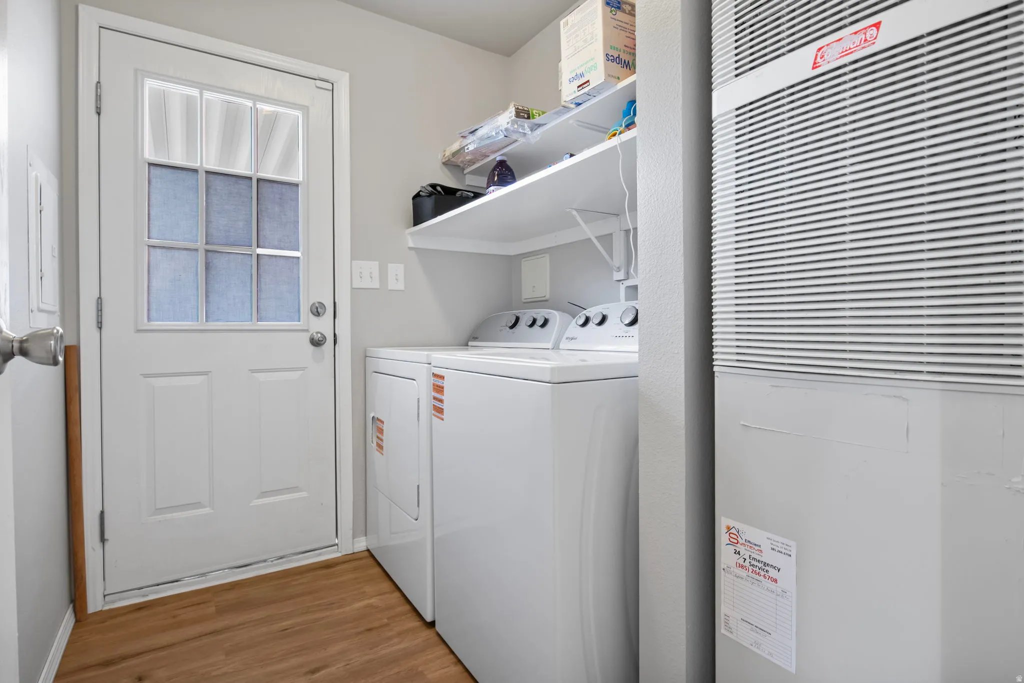 Laundry area with a heating unit, light wood finished floors, and independent washer and dryer