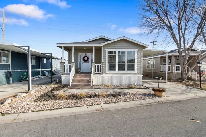 Manufactured / mobile home with a porch, an attached carport, and driveway