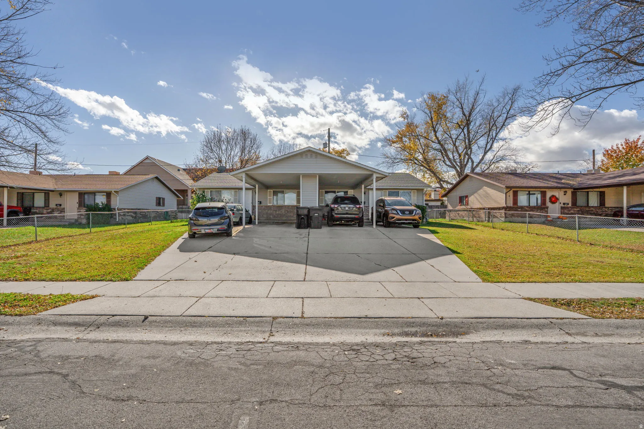 View of front of house featuring concrete driveway, a residential view, and a carport
