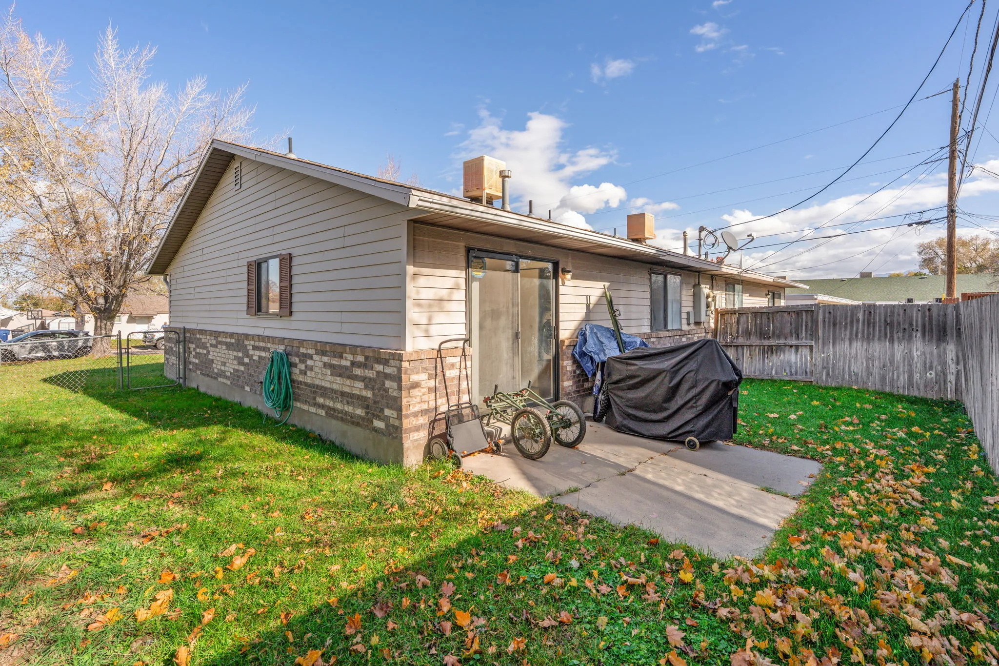 Back of property featuring a fenced backyard, brick siding, and a patio area