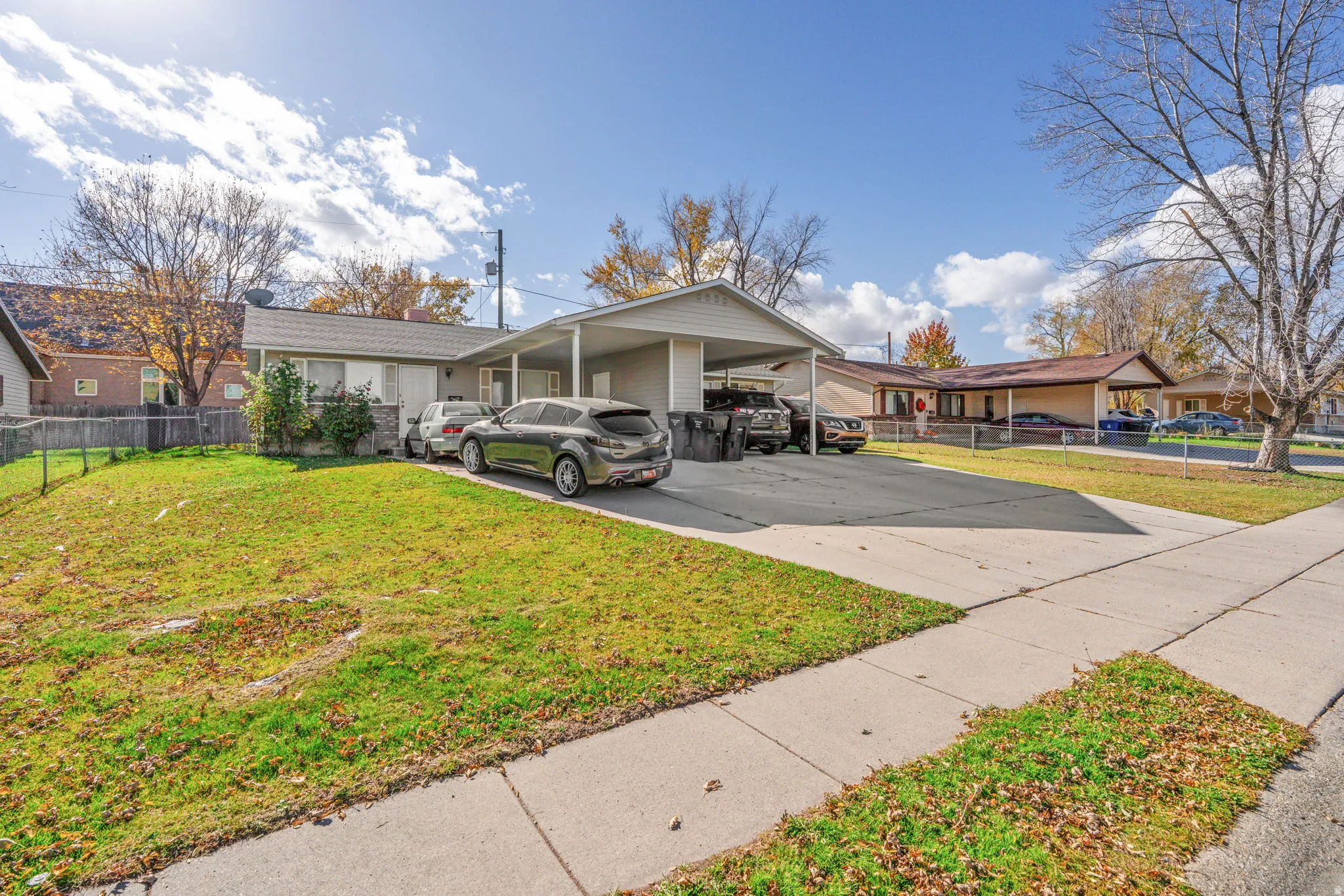 View of front of property with concrete driveway and an attached carport