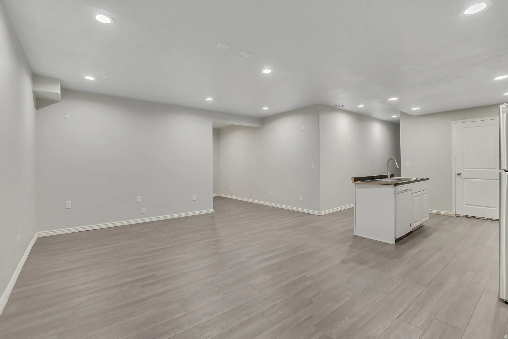 Basement with light wood-style flooring and recessed lighting