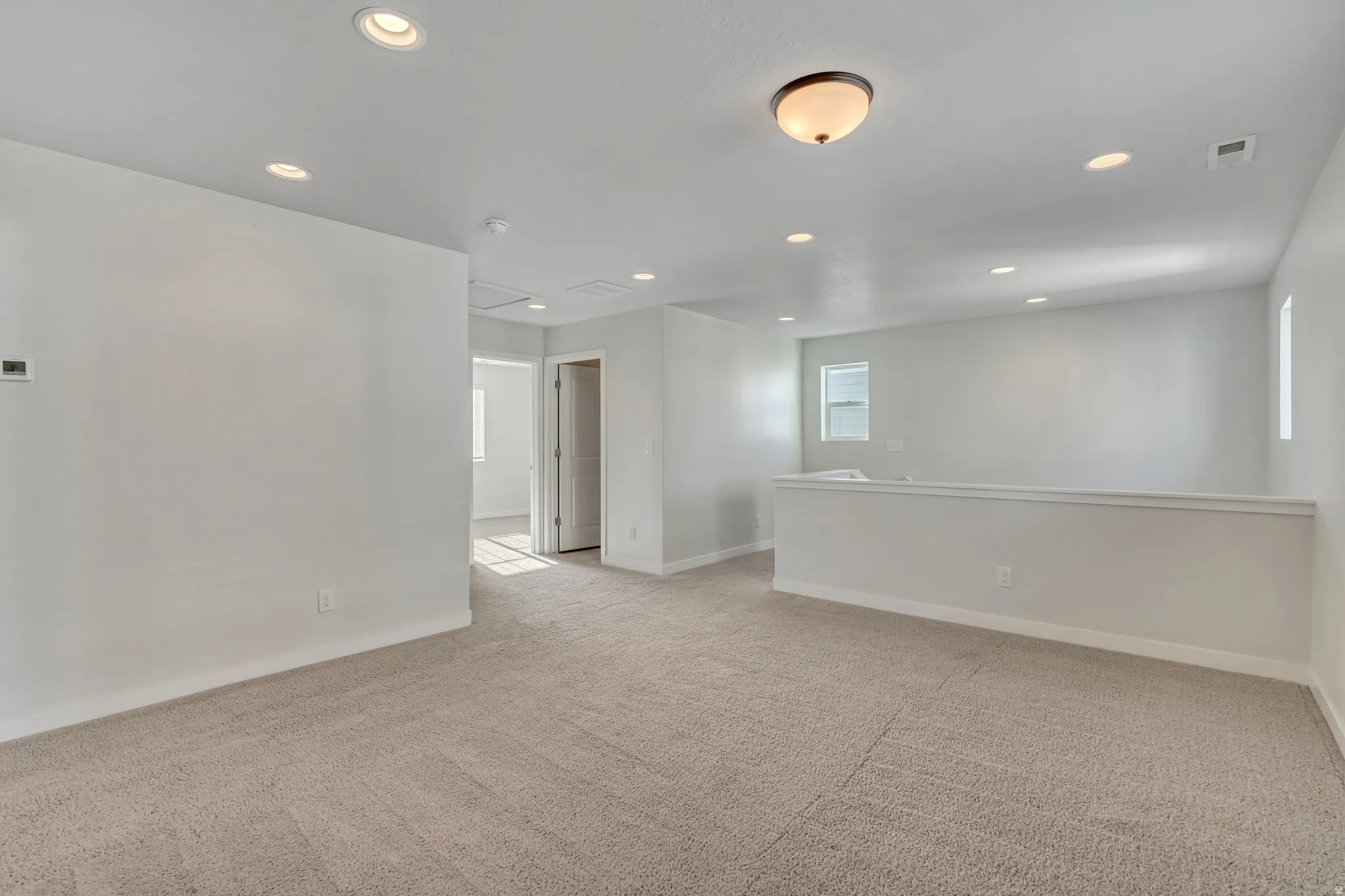 Empty room featuring recessed lighting and light colored carpet