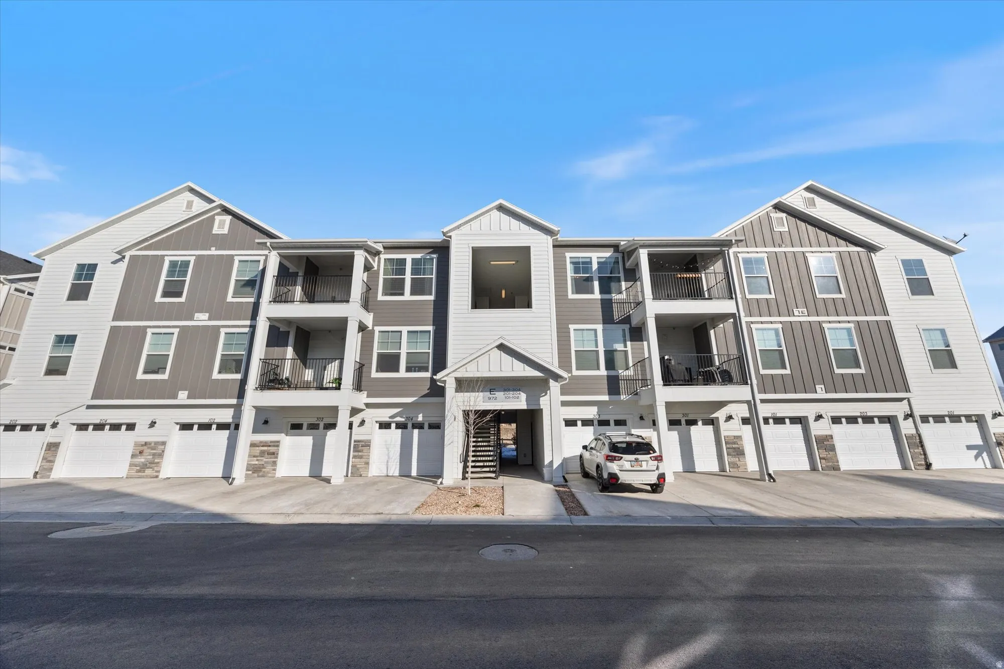 View of apartment building / complex featuring driveway and an attached garage