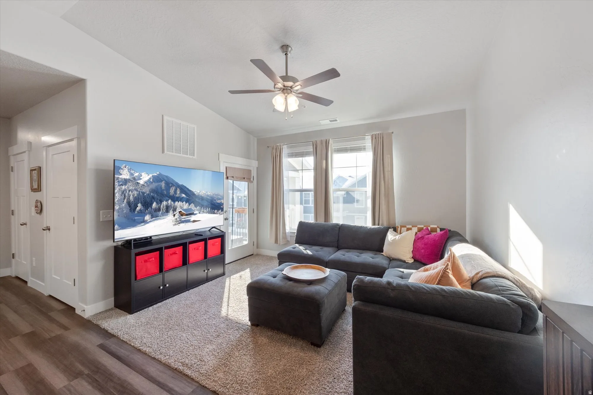 Living room with vaulted ceiling, wood finished floors, and ceiling fan