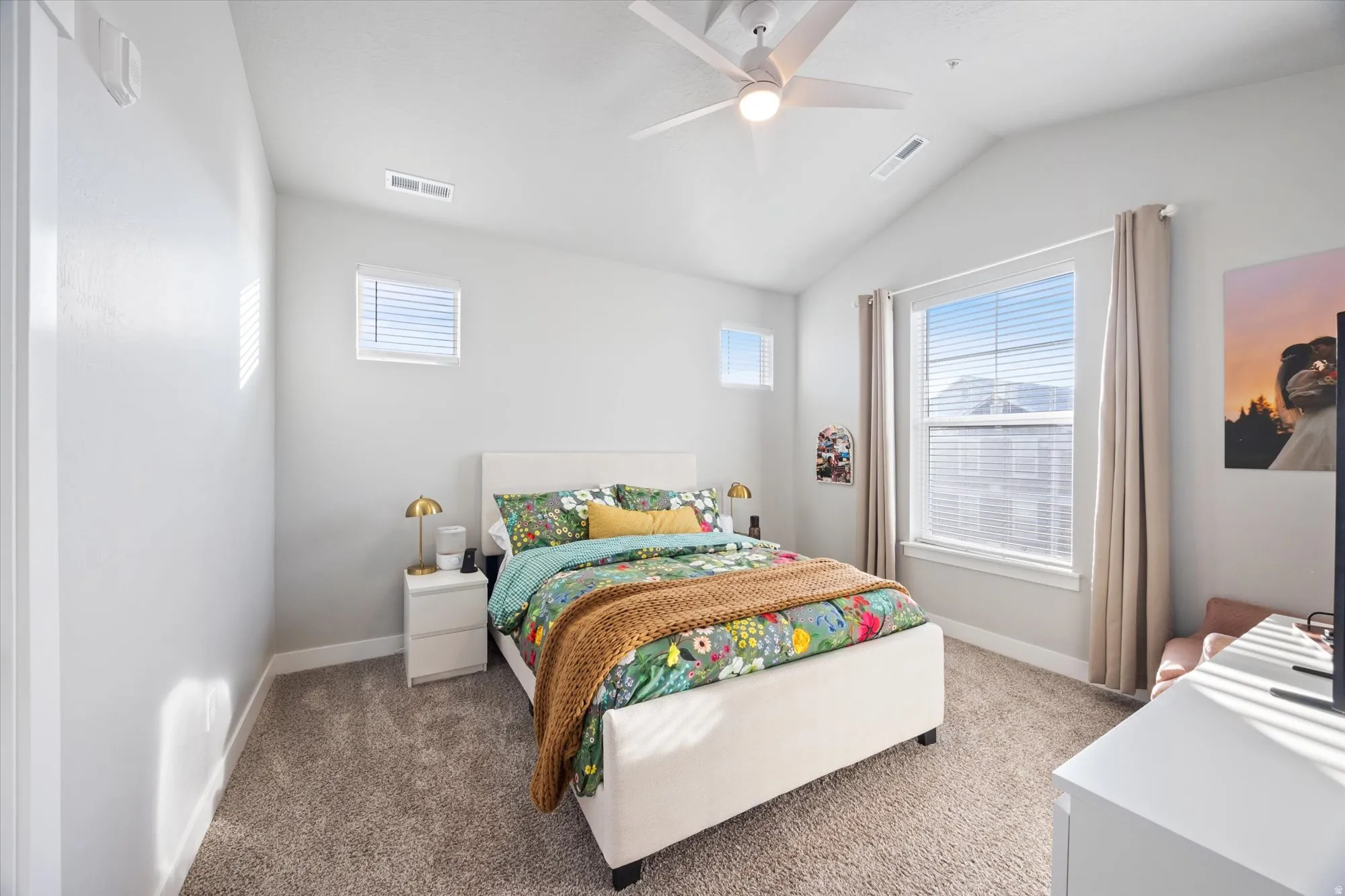 Bedroom with light carpet, vaulted ceiling, and a ceiling fan
