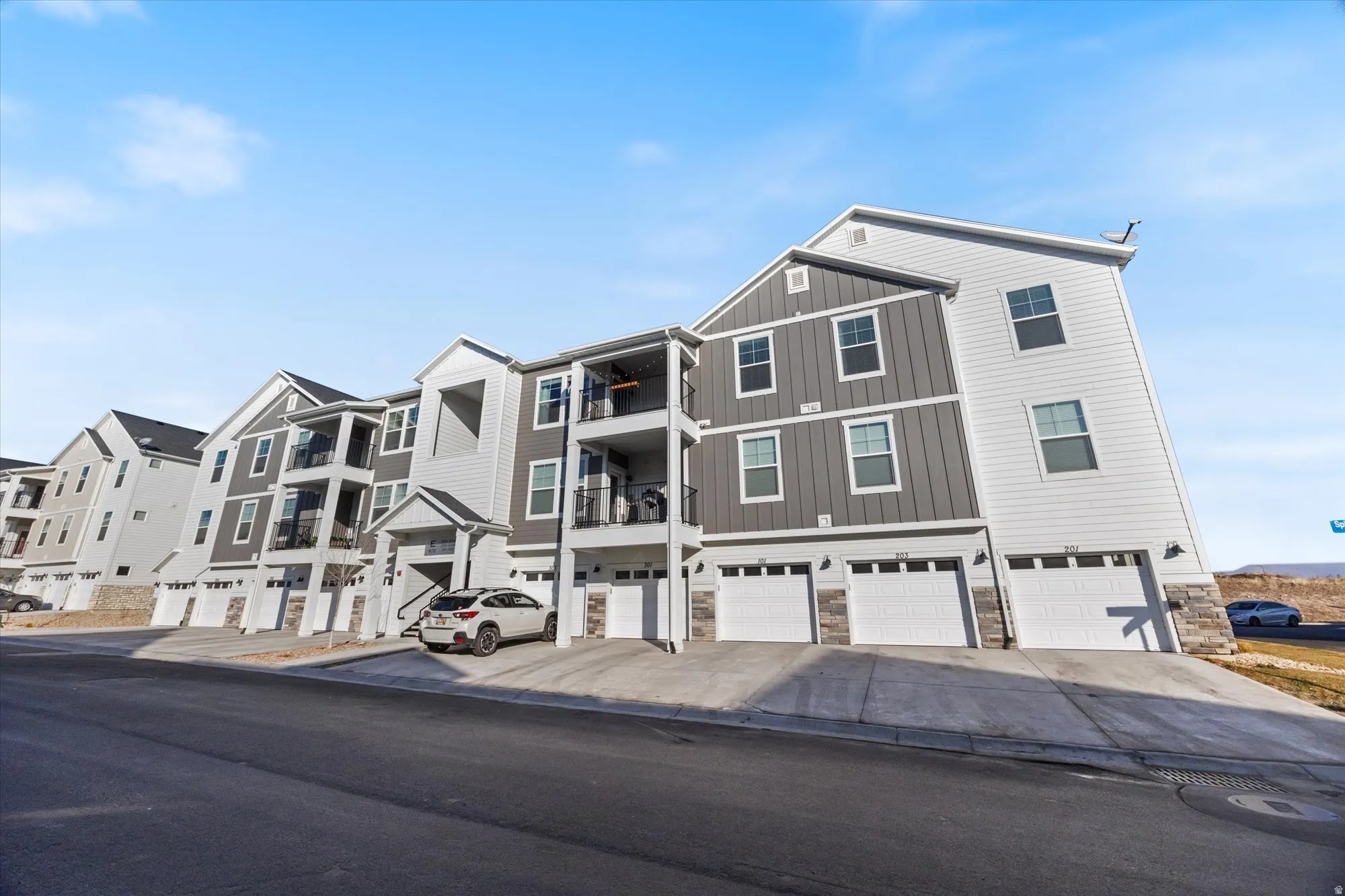 View of front of property with an attached garage, stone siding, and driveway