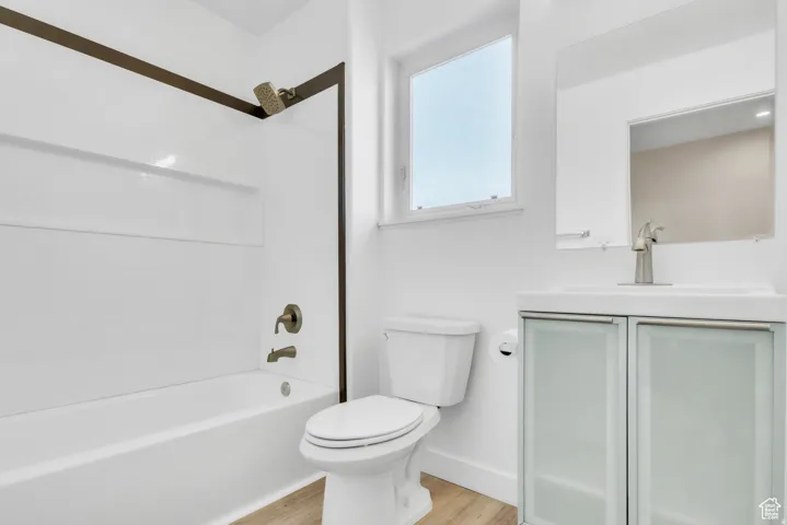 Bathroom featuring shower / bath combination, vanity, and light wood finished floors