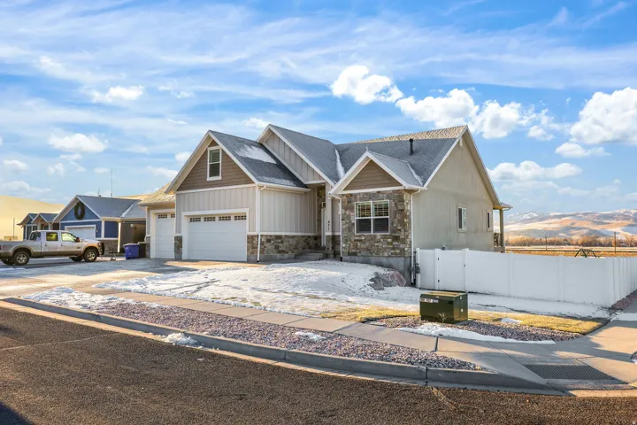 Craftsman-style house with stone siding, driveway, a mountain view, and a shingled roof