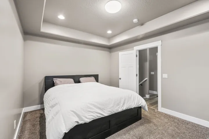 Bedroom with carpet floors, recessed lighting, a tray ceiling, and a textured ceiling