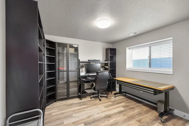 Office area featuring a textured ceiling and light wood finished floors