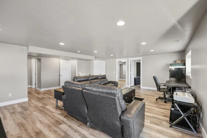 Living room featuring light wood-type flooring, recessed lighting, a textured ceiling, and a desk