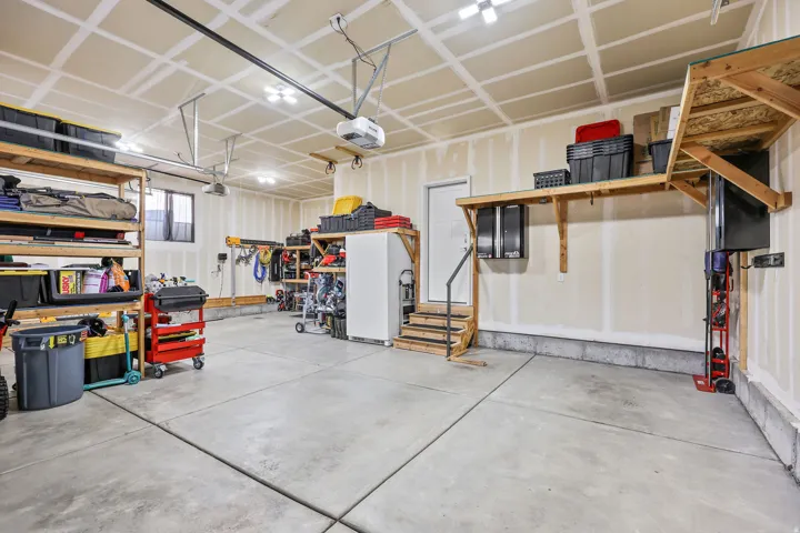 Garage featuring freestanding refrigerator and a garage door opener