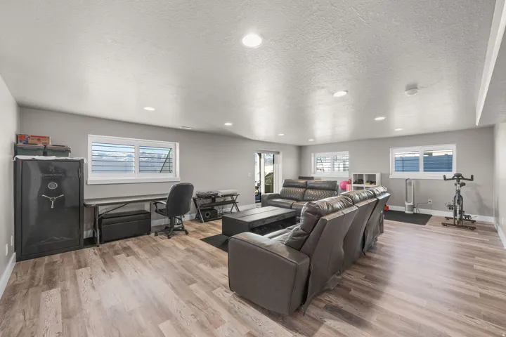 Living room featuring a desk, recessed lighting, a textured ceiling, and light wood-style floors