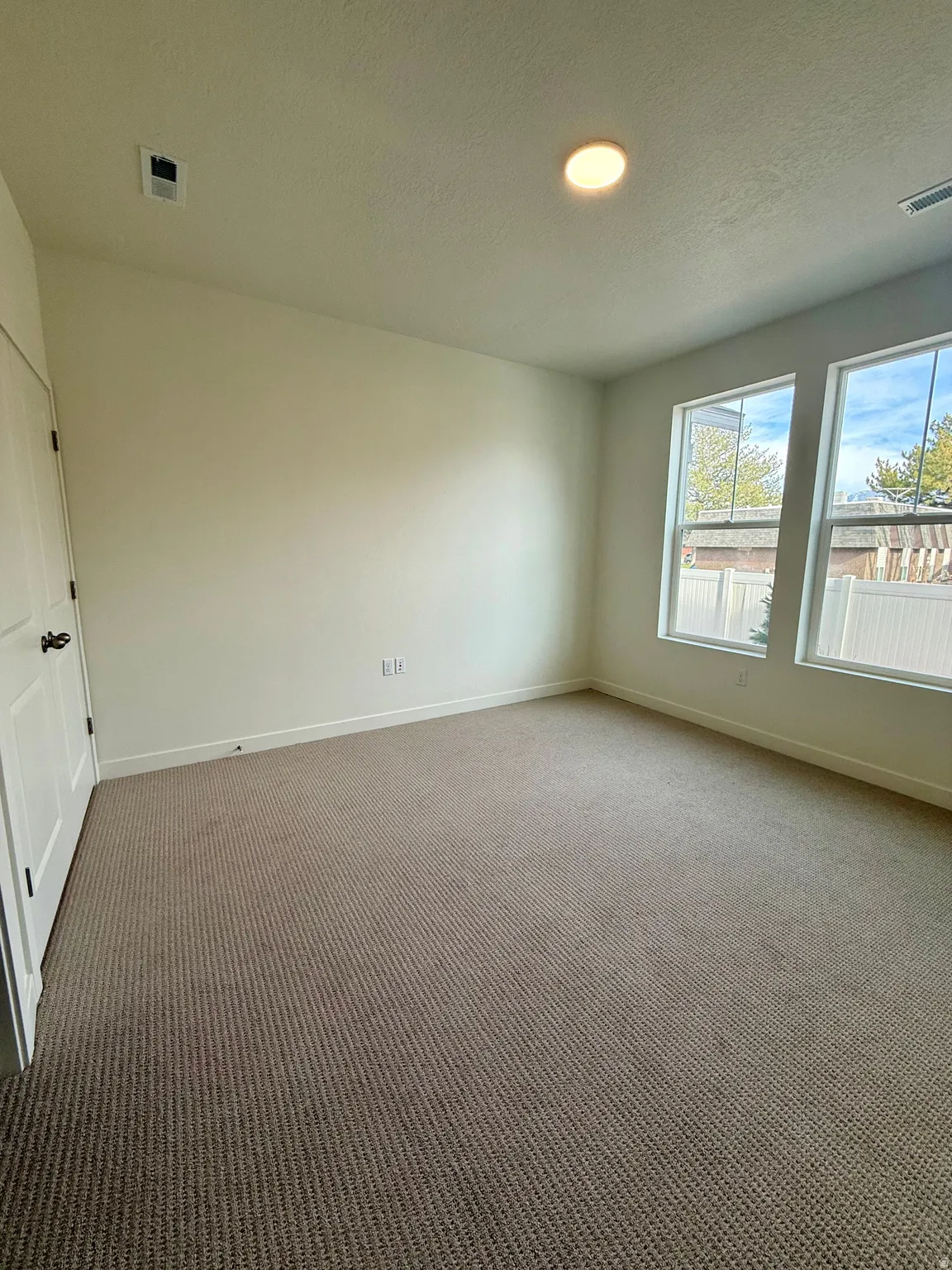 Unfurnished room featuring a textured ceiling and carpet flooring