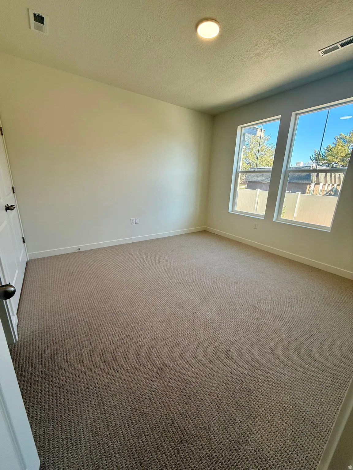 Unfurnished room with carpet flooring and a textured ceiling
