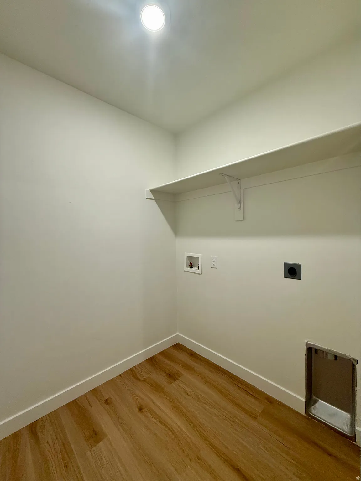 Laundry area featuring light wood-style flooring, hookup for a washing machine, and electric dryer hookup