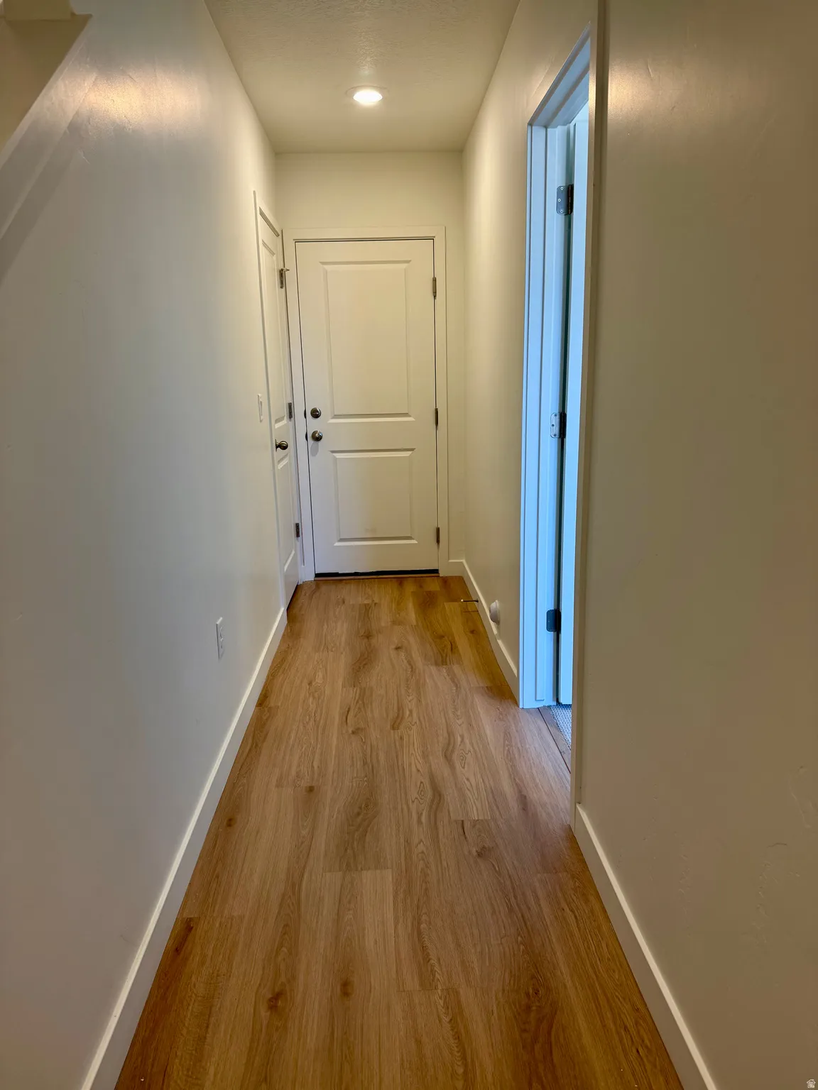 Hall with baseboards and light wood finished floors