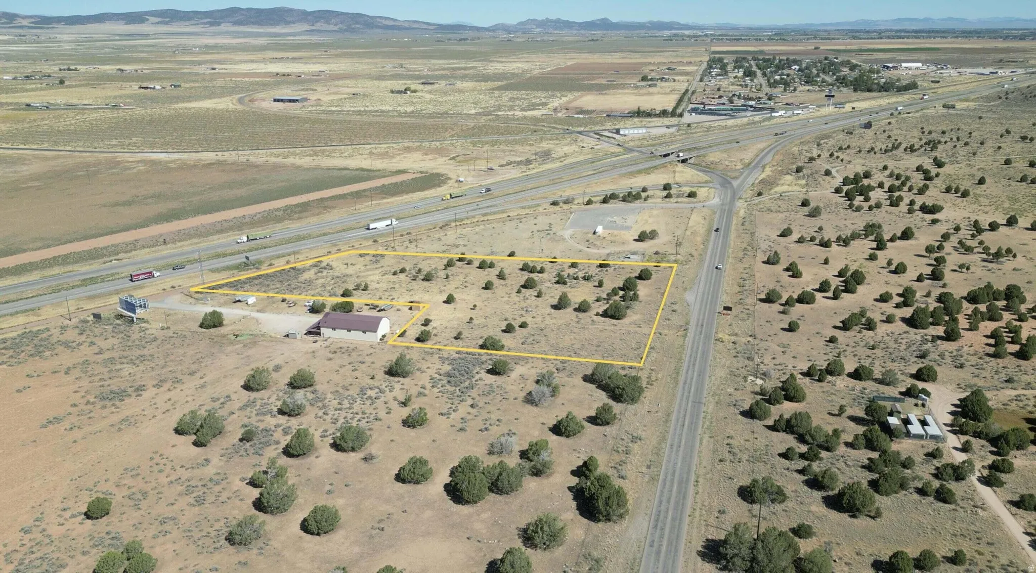 Aerial overview of property's location with rural landscape, property boundaries highlighted, and mountains