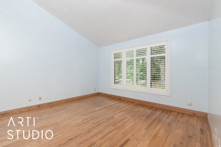 Spare room featuring lofted ceiling and light wood-style flooring