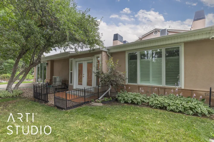 Property entrance featuring a chimney, stucco siding, and a yard