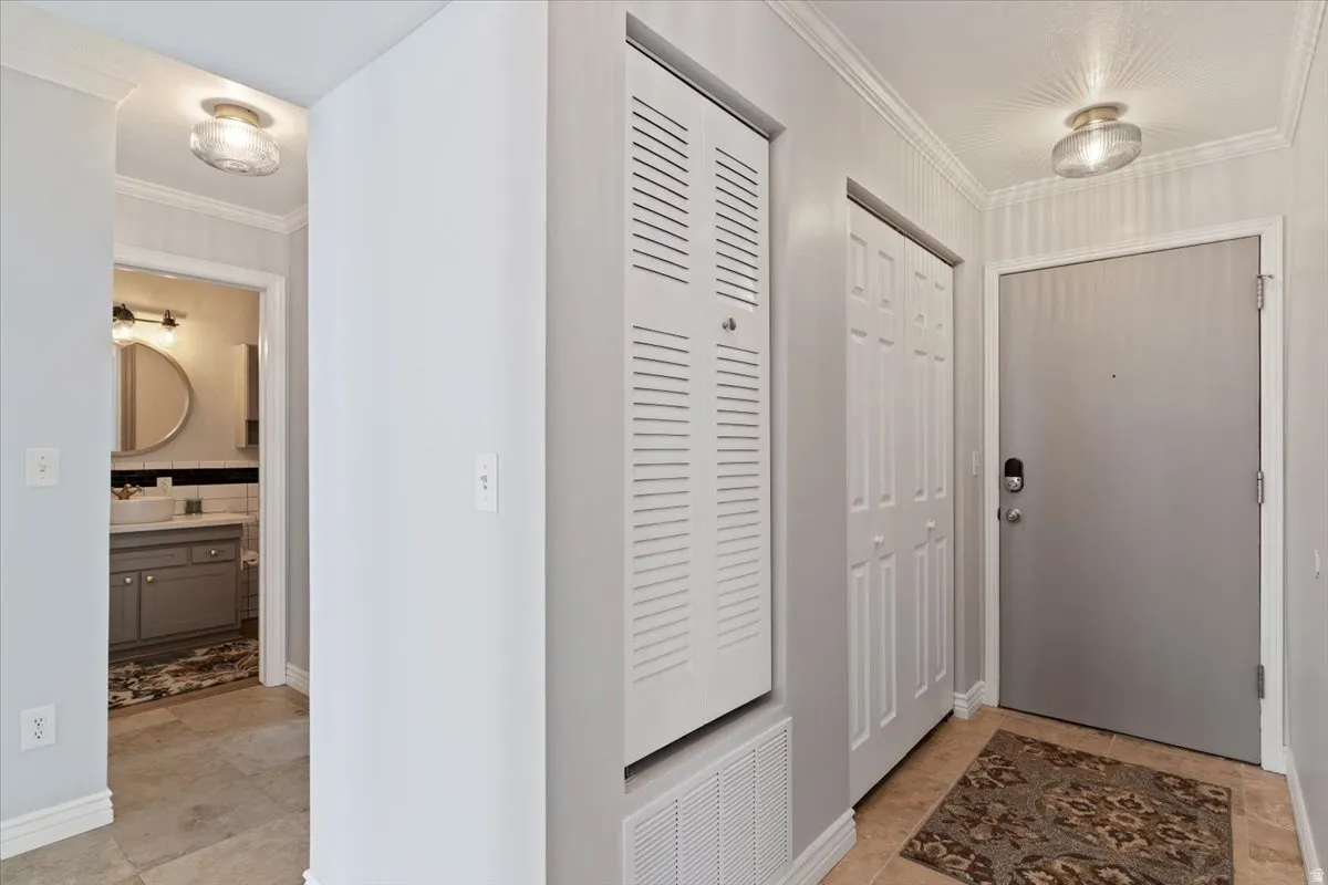 Foyer entrance featuring ornamental molding and light tile patterned floors