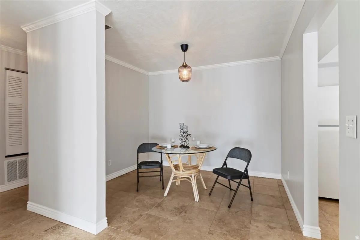 Dining room with crown molding and baseboards