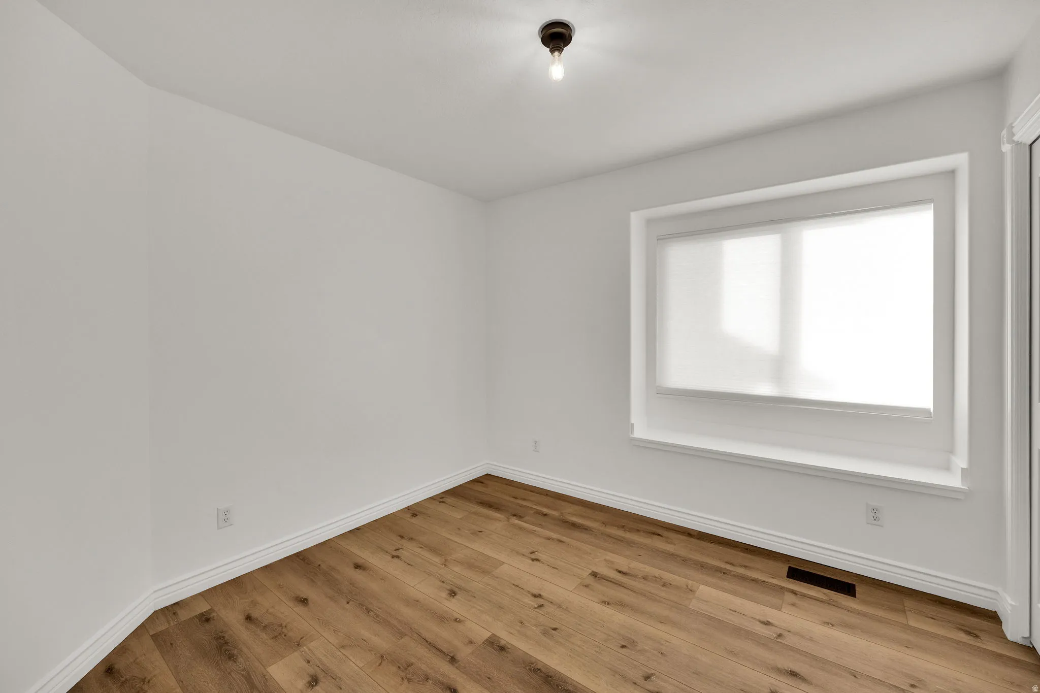 Empty room with light wood finished floors and baseboards