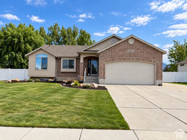 Brick and stucco exterior with an attached two-car garage