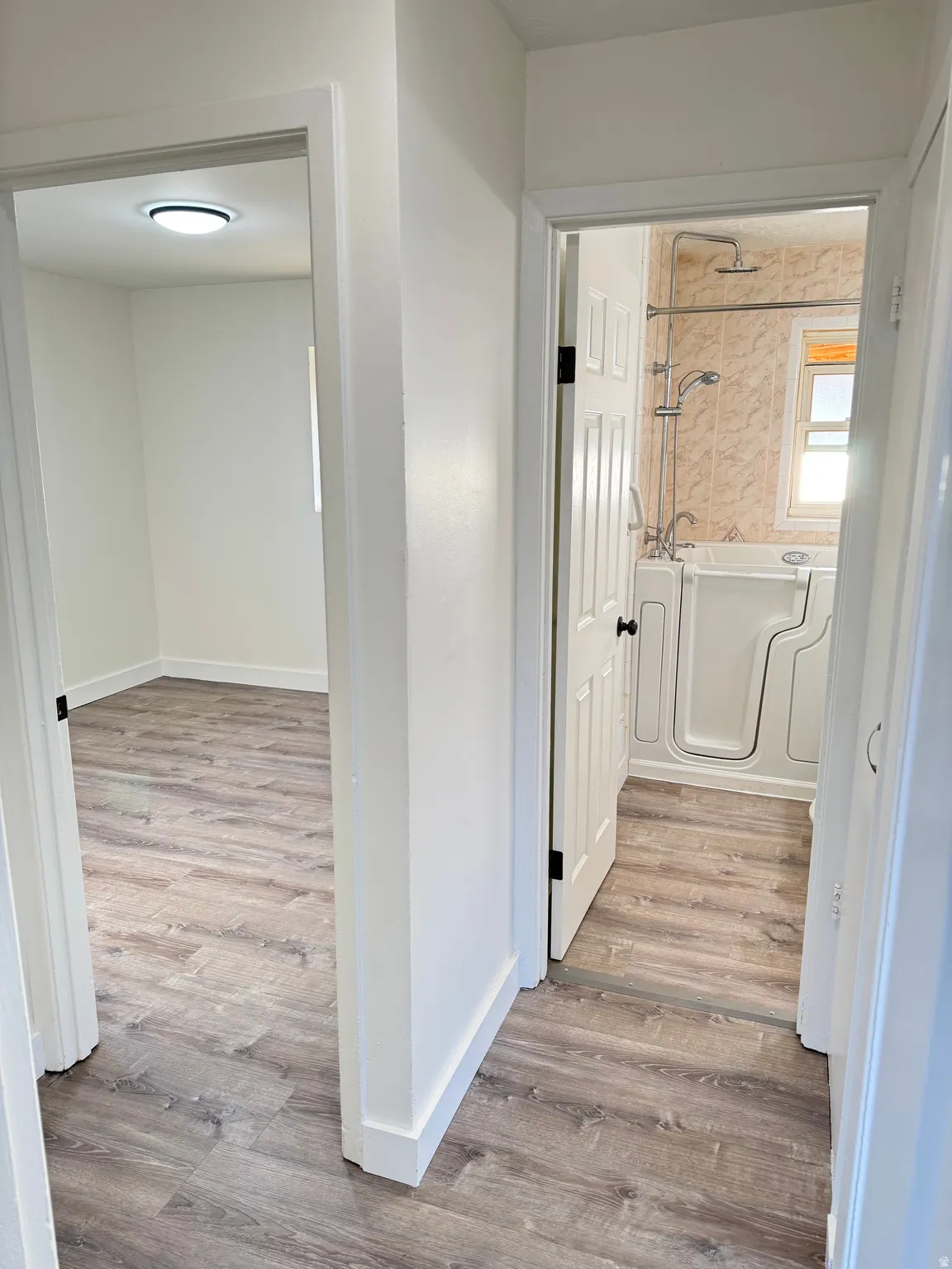 Hall with light wood-style flooring and baseboards