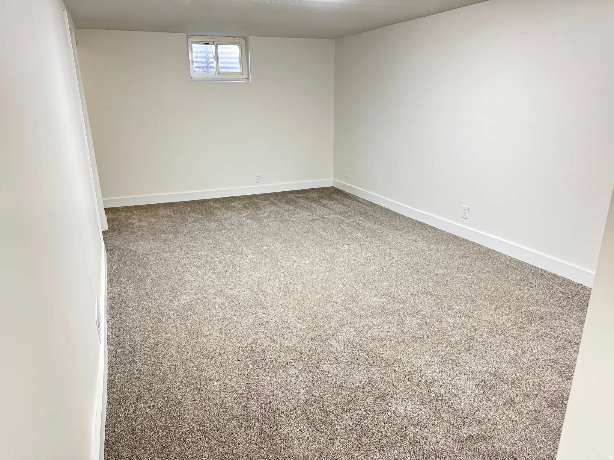 Basement with light carpet and baseboards