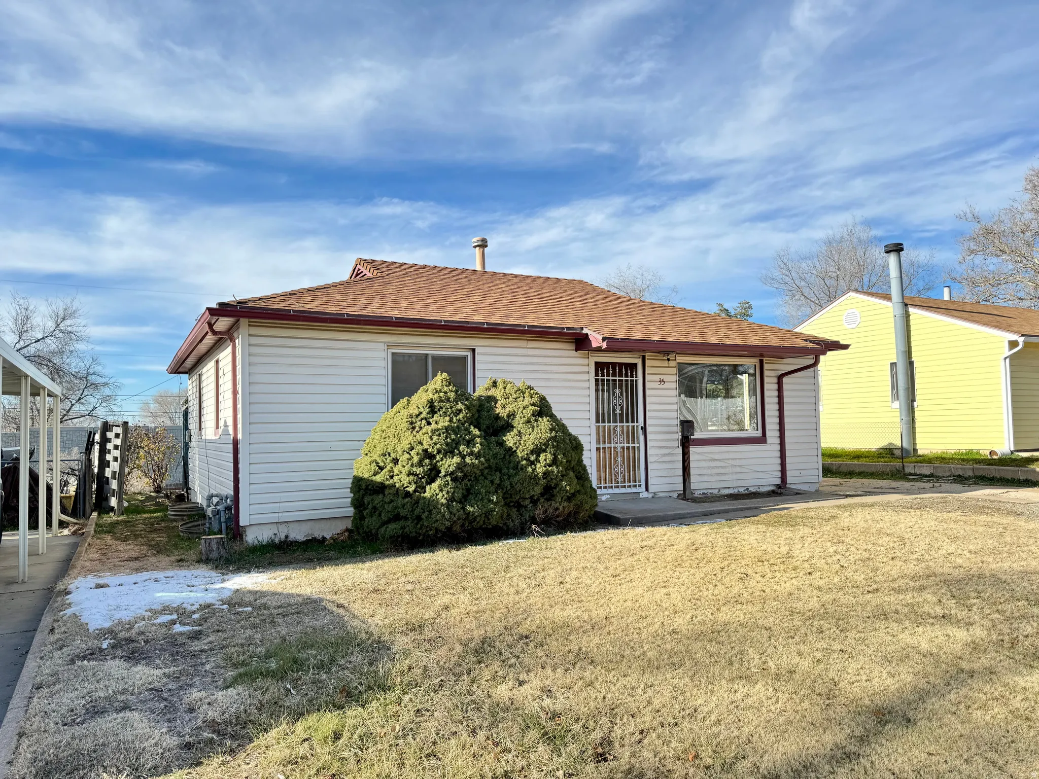 View of front of home with roof with shingles and a front lawn