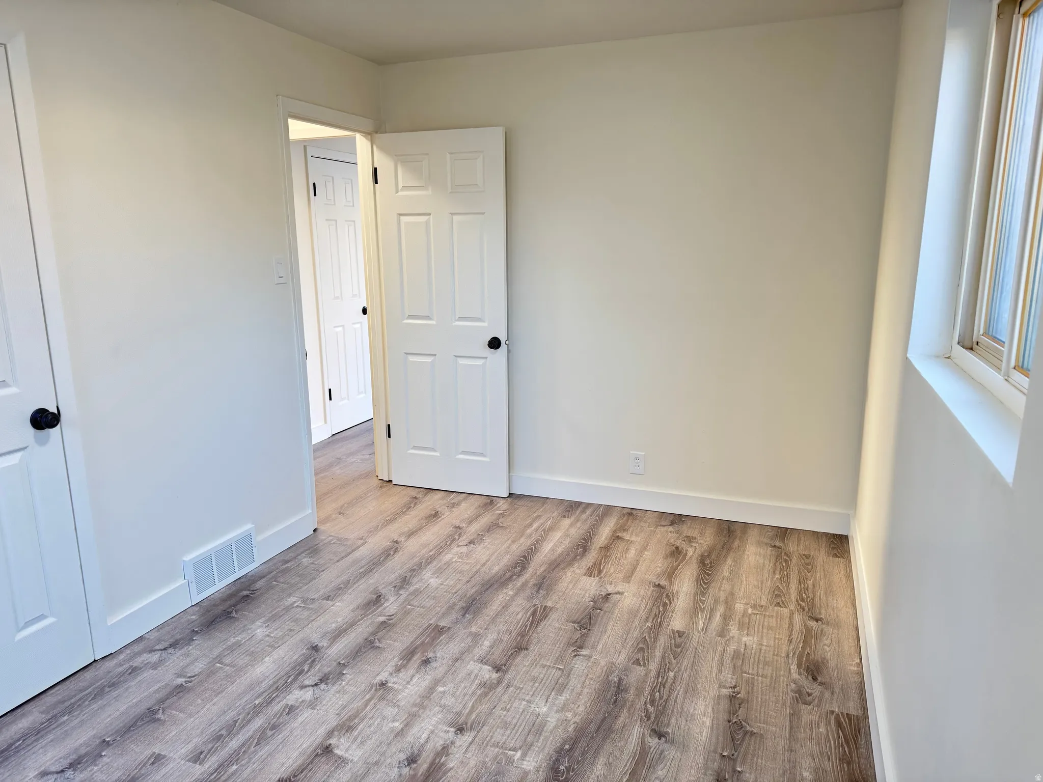 Unfurnished bedroom featuring light wood-style flooring and baseboards