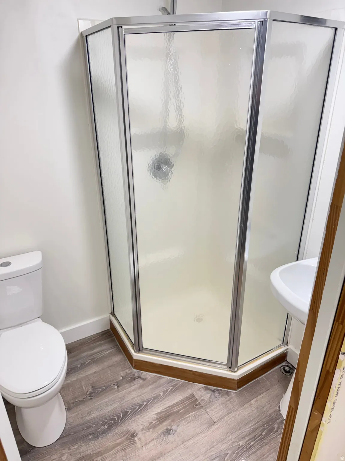 Full bathroom with light wood-type flooring and a stall shower