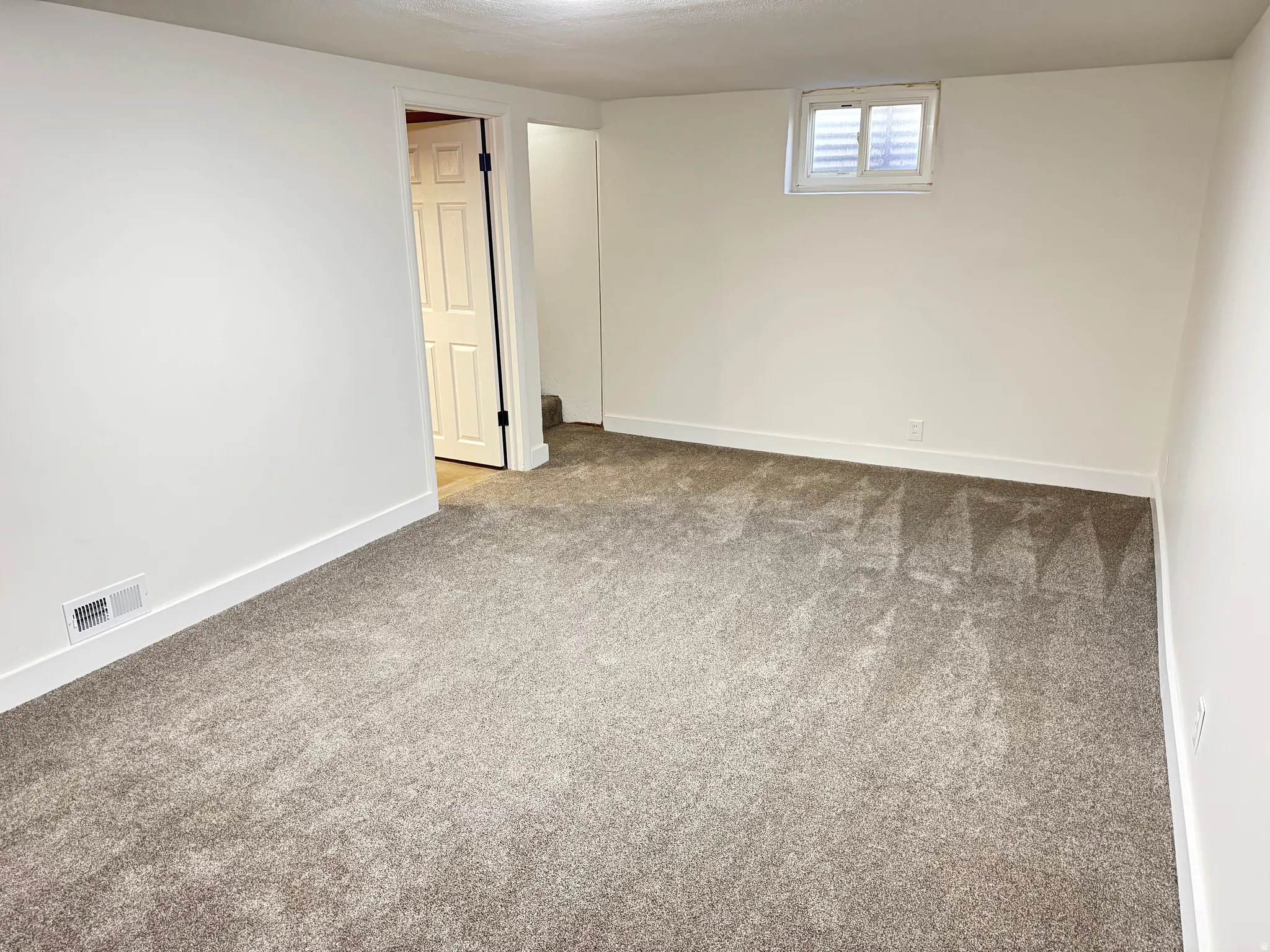 Basement featuring carpet and baseboards