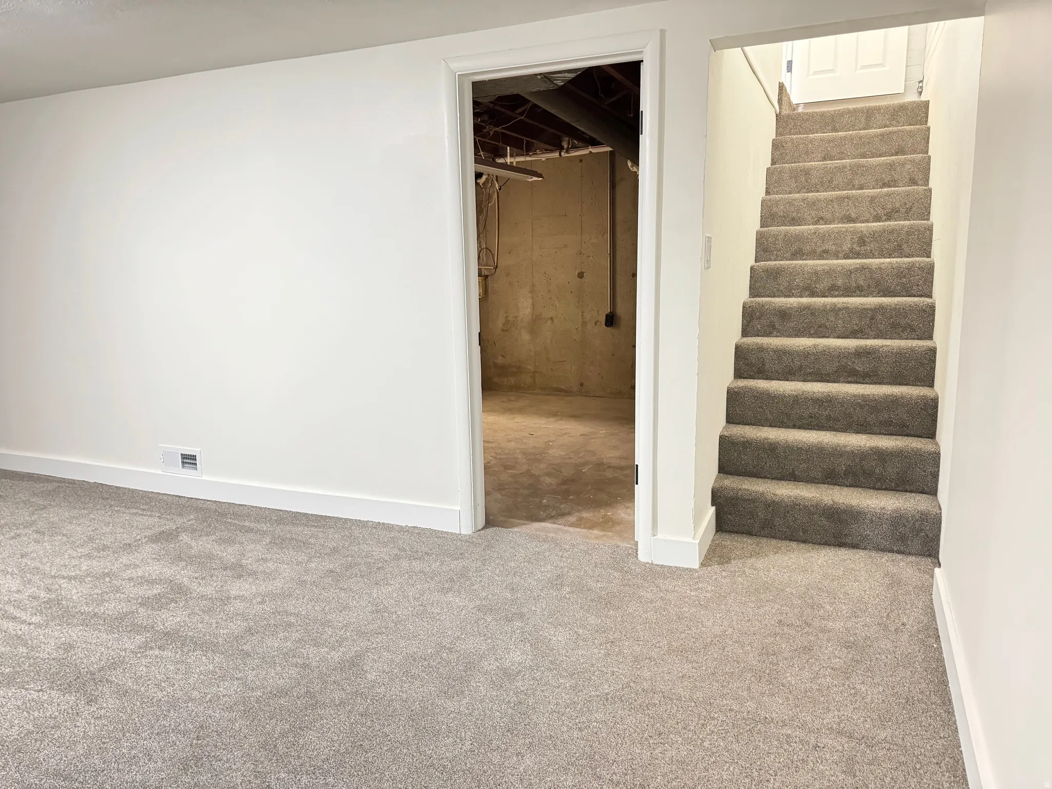 Finished basement featuring carpet and stairs