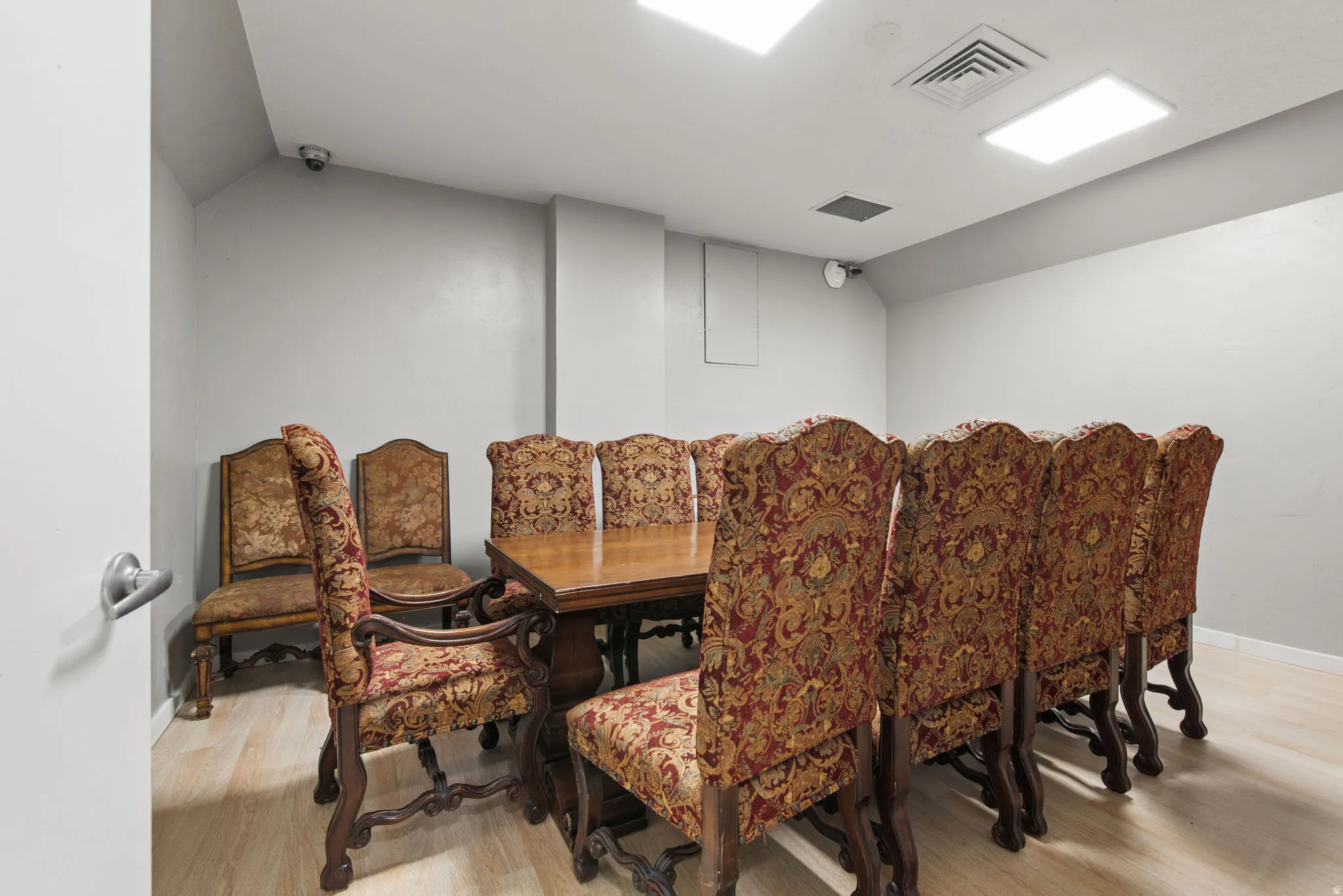 Dining space with light wood-type flooring and lofted ceiling